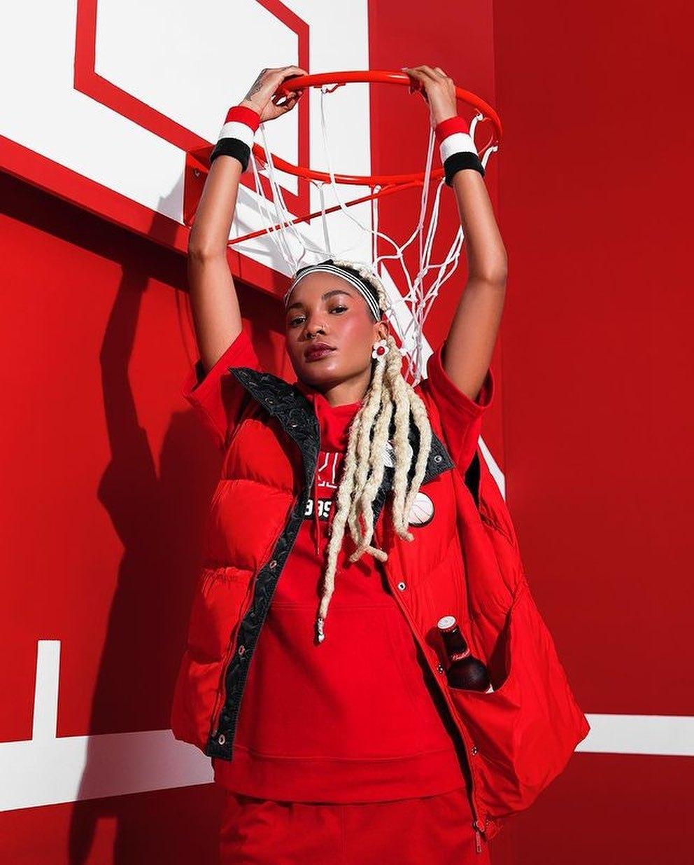 Modelo de look vermelho em quadra de basquete na campanha da Budweiser